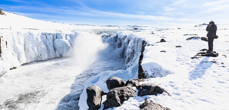 Winter scenery of Godafoss with a photographer in the background / Copyright: Visit North Iceland